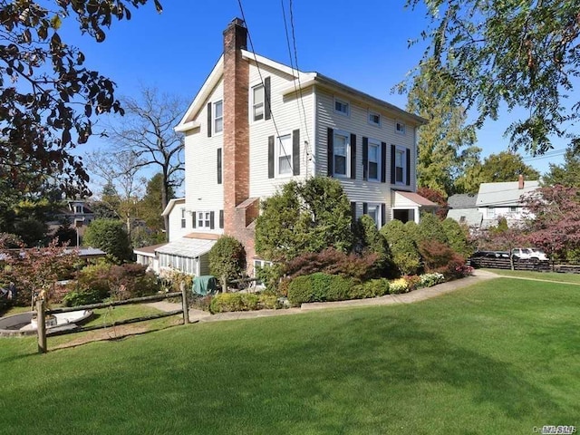 view of property exterior with a lawn and a chimney