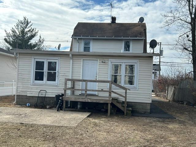 rear view of property featuring a chimney