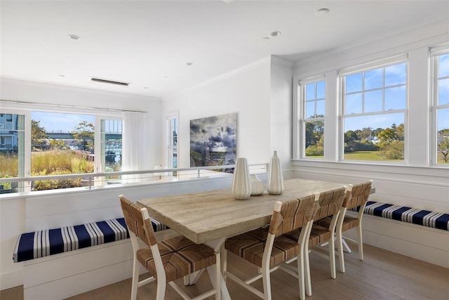 dining room with ornamental molding, visible vents, and light wood-style flooring