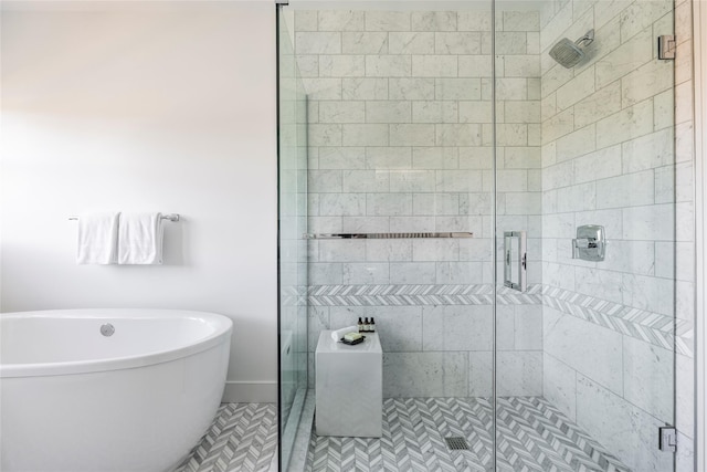 bathroom featuring a stall shower and a freestanding bath