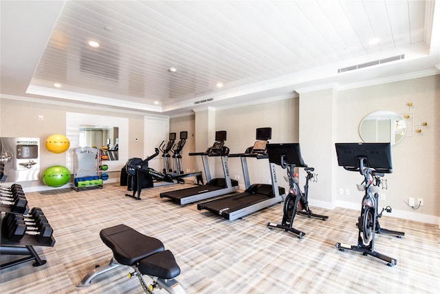 exercise room with baseboards, visible vents, a tray ceiling, crown molding, and carpet floors