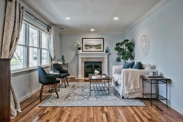 living room featuring a glass covered fireplace, wood finished floors, and ornamental molding