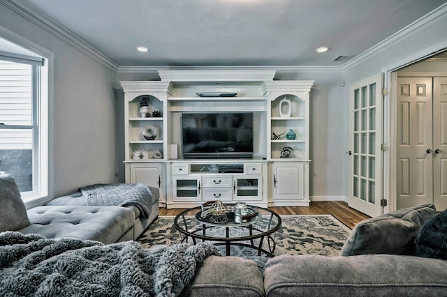 living area featuring visible vents, wood finished floors, and crown molding