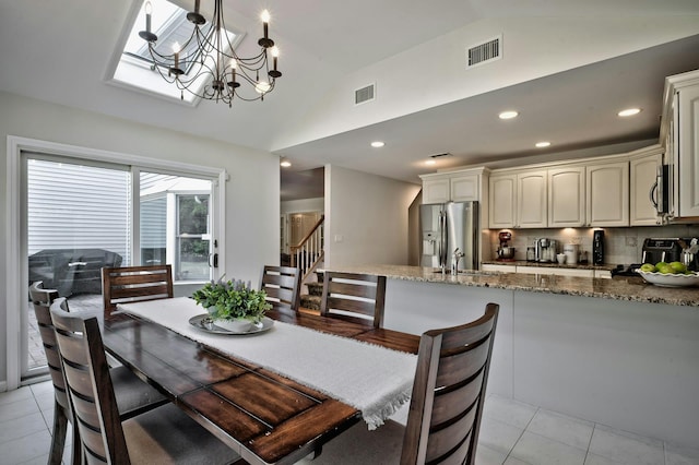 dining space featuring light tile patterned flooring, visible vents, and vaulted ceiling