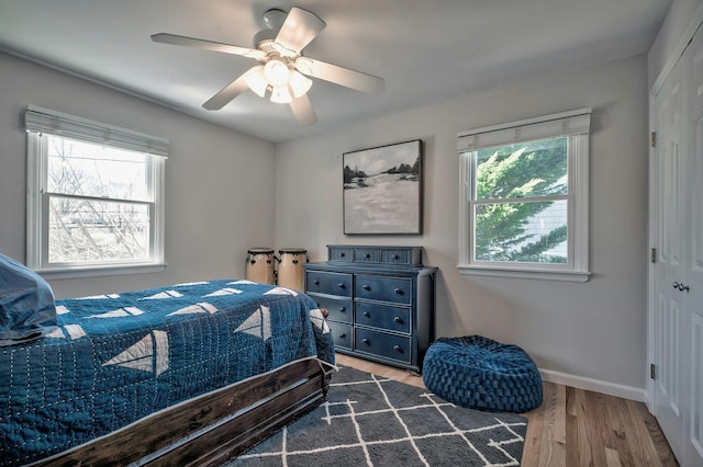 bedroom featuring a ceiling fan, wood finished floors, and baseboards