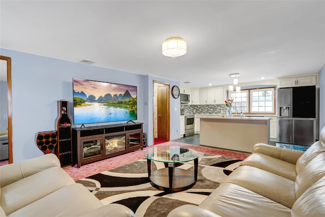 living area with a multi sided fireplace, visible vents, recessed lighting, and wood finished floors