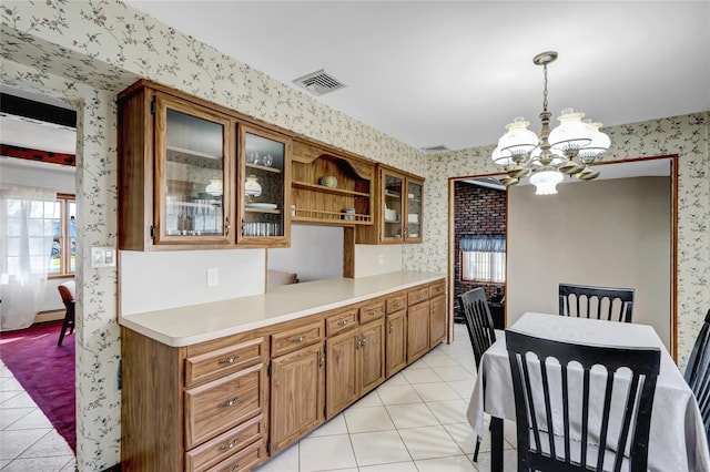 kitchen with glass insert cabinets, visible vents, wallpapered walls, and light countertops