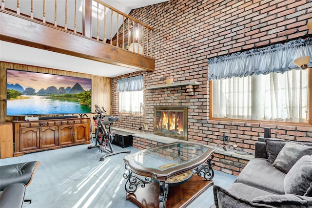 living area with a brick fireplace, brick wall, a towering ceiling, and carpet floors