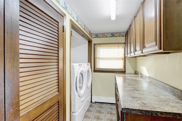 washroom with washer and dryer, baseboards, and cabinet space