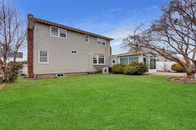 back of property featuring ac unit, a lawn, and fence