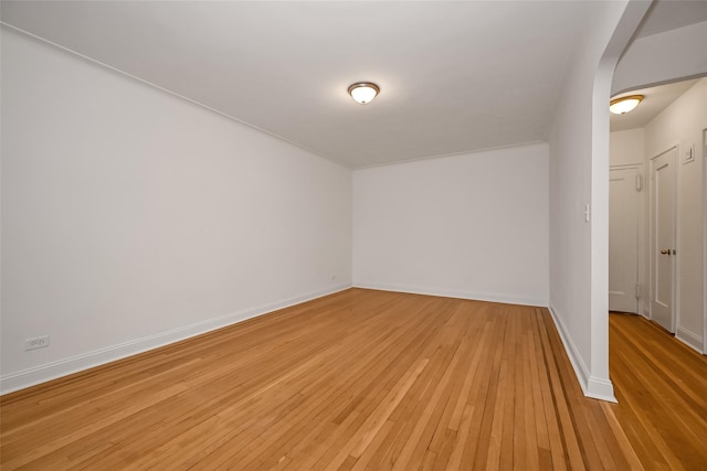 empty room featuring light wood-type flooring and baseboards