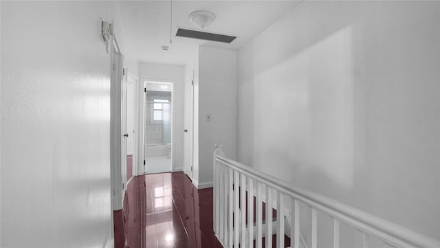 hallway featuring a wainscoted wall, dark wood-type flooring, an upstairs landing, and visible vents