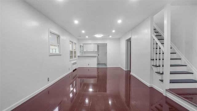 interior space with baseboards, stairway, wood finished floors, and recessed lighting