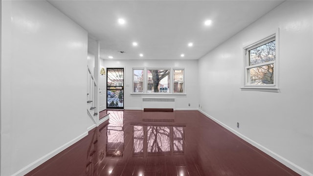 interior space featuring dark wood-style floors, radiator heating unit, recessed lighting, and baseboards