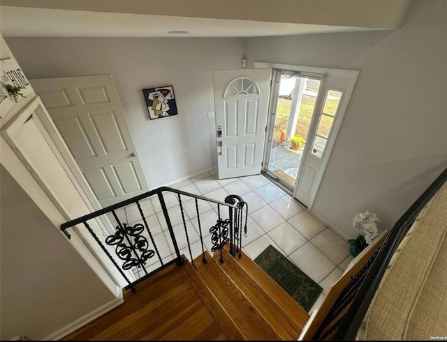 entryway with lofted ceiling and light tile patterned floors