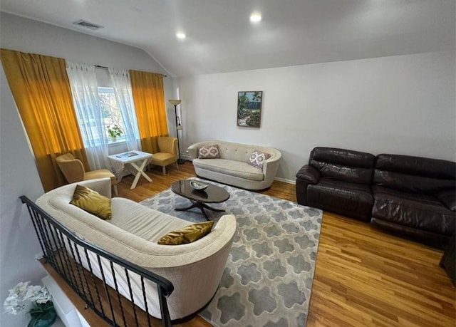 living room with lofted ceiling, visible vents, wood finished floors, and recessed lighting