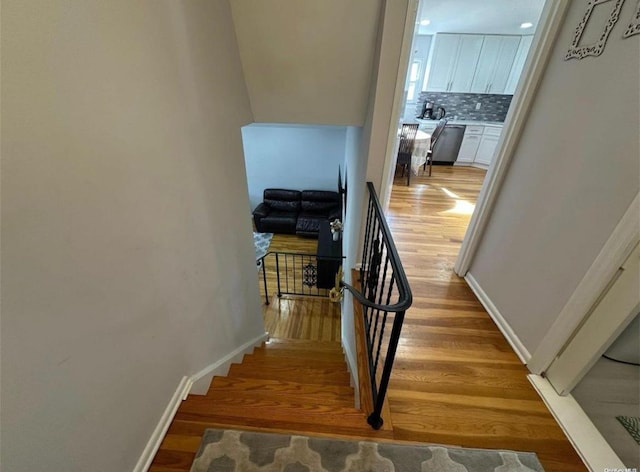 stairway featuring baseboards and wood finished floors