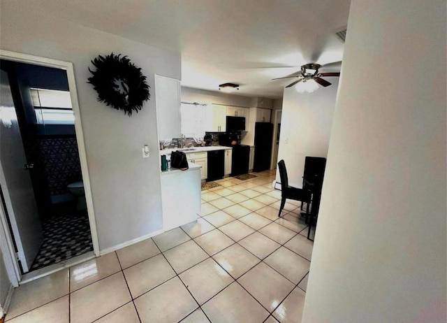 kitchen with light countertops, white cabinetry, ceiling fan, light tile patterned flooring, and black appliances