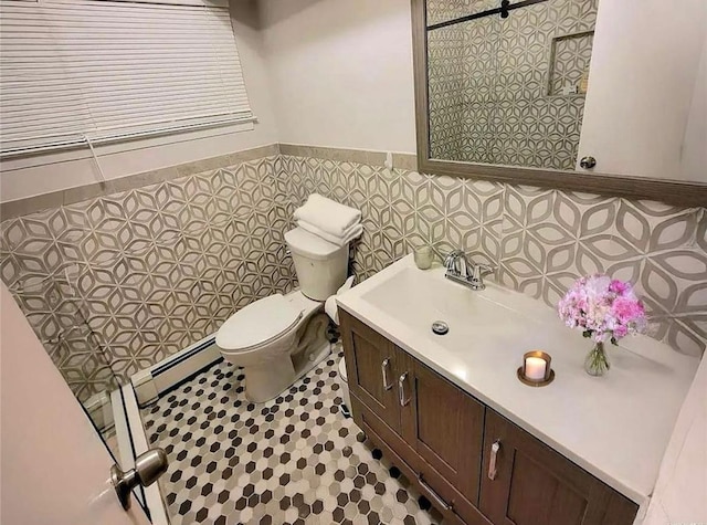 bathroom with tile walls, wainscoting, vanity, and toilet