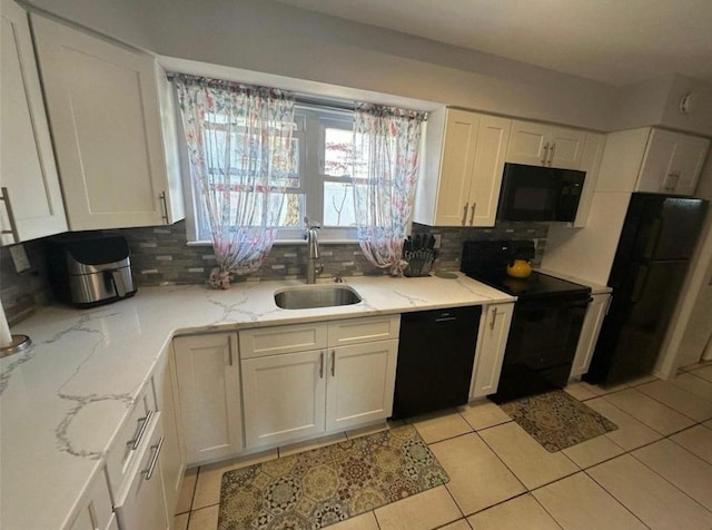 kitchen featuring black appliances, tasteful backsplash, white cabinets, and a sink