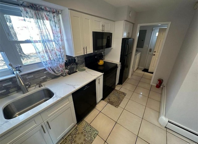 kitchen with light tile patterned floors, decorative backsplash, white cabinetry, a sink, and black appliances