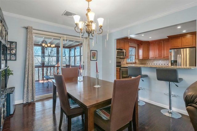 dining room with a chandelier, dark wood-style floors, and ornamental molding