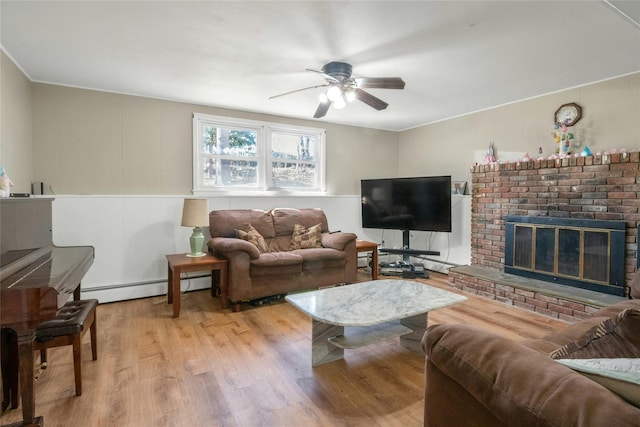 living room with a ceiling fan, a brick fireplace, wood finished floors, and baseboard heating