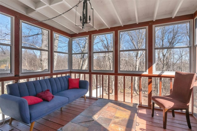 sunroom featuring beam ceiling and a notable chandelier