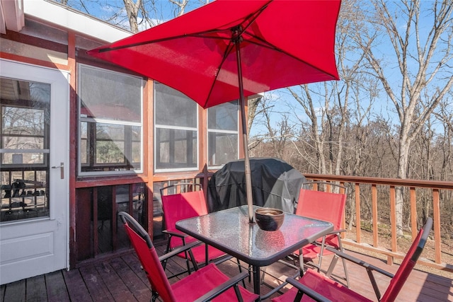 wooden deck featuring a grill and outdoor dining area