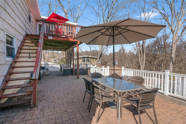 view of patio / terrace featuring stairway, outdoor dining area, and a wooden deck