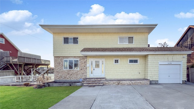 view of front of house with a garage, driveway, roof with shingles, and a front yard