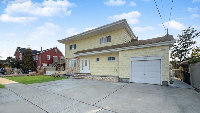 view of front of property with driveway, an attached garage, and fence