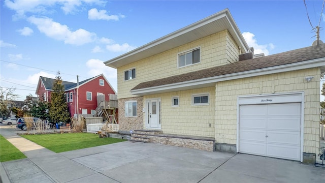 view of front of house featuring driveway, a front yard, a garage, and roof with shingles