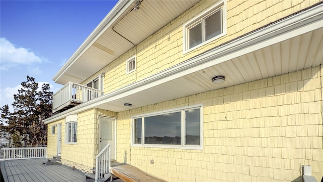 view of side of property featuring a balcony and entry steps