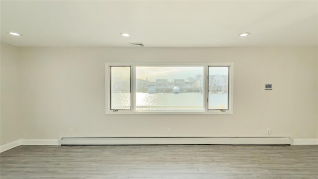 unfurnished room featuring light wood finished floors, a baseboard radiator, recessed lighting, visible vents, and baseboards