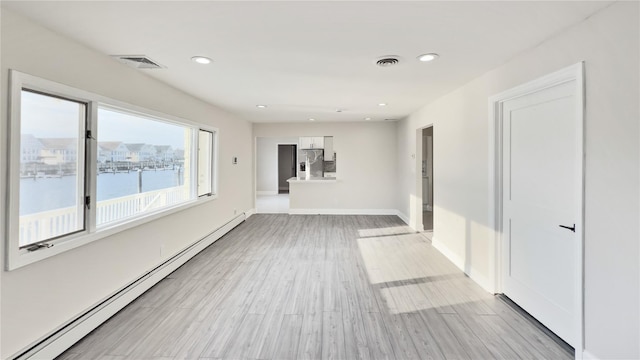 unfurnished room featuring light wood-type flooring, a baseboard radiator, visible vents, and recessed lighting