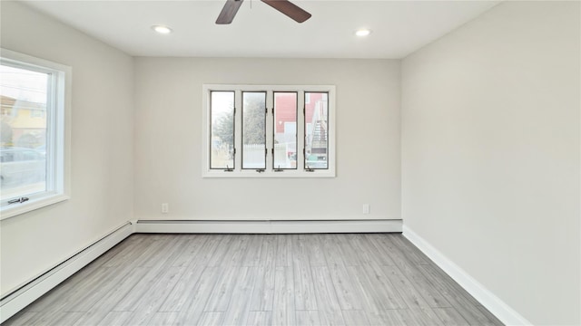 empty room featuring light wood finished floors, baseboards, baseboard heating, and a baseboard heating unit