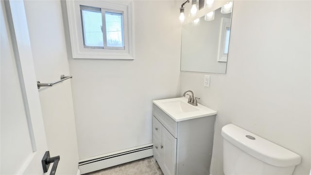 half bathroom with a baseboard radiator, vanity, and toilet