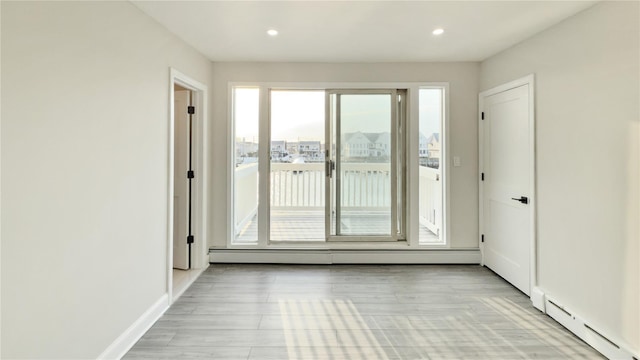 empty room with baseboards, baseboard heating, and recessed lighting