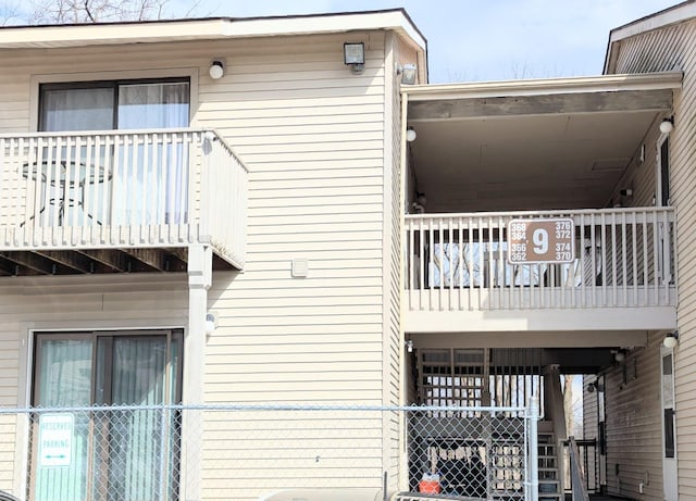 view of side of home with fence and a balcony