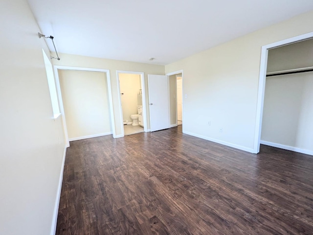 unfurnished bedroom featuring a closet, baseboards, and dark wood-style flooring