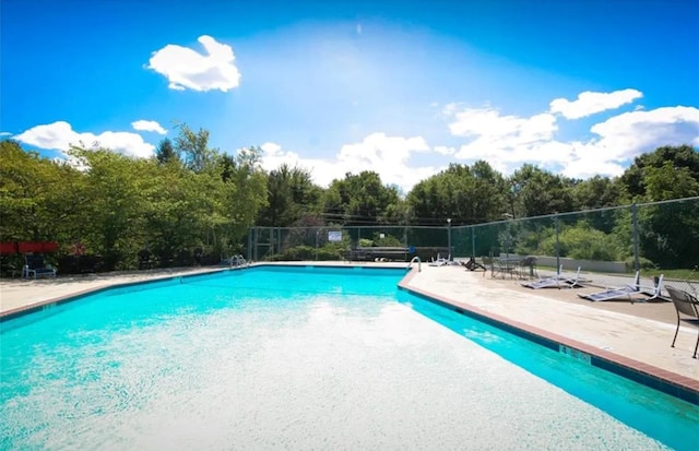 pool with a patio and fence