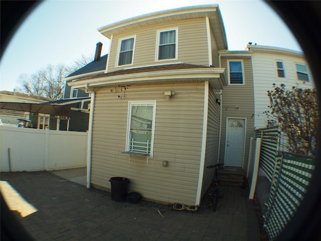 back of property featuring entry steps and fence