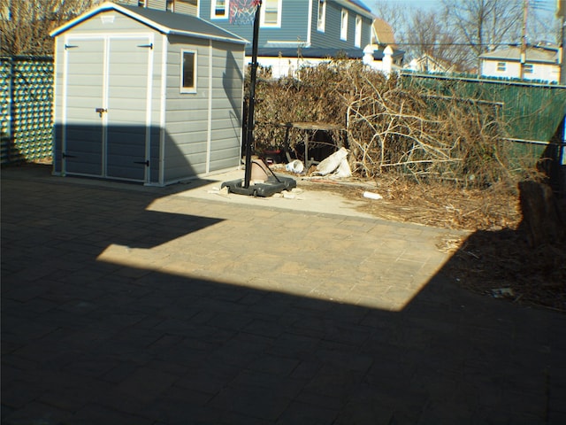 rear view of property with an outbuilding, a storage unit, and fence