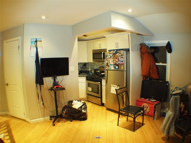 kitchen with decorative backsplash, recessed lighting, light wood-style flooring, appliances with stainless steel finishes, and white cabinets