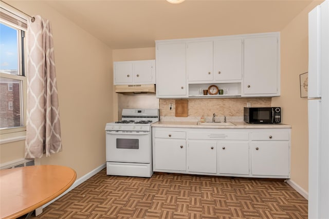 kitchen with white range with gas cooktop, light countertops, under cabinet range hood, black microwave, and a sink