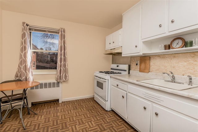 kitchen featuring light countertops, radiator heating unit, a sink, white range with gas stovetop, and under cabinet range hood