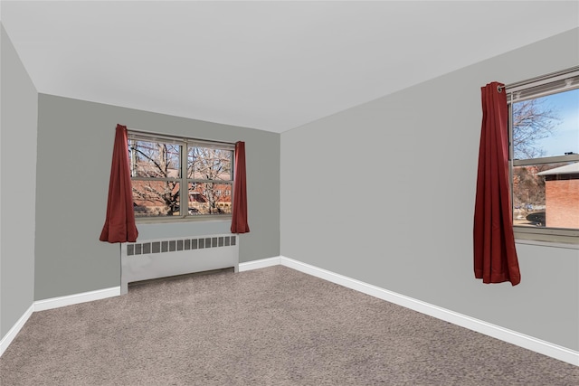 empty room featuring radiator heating unit and baseboards