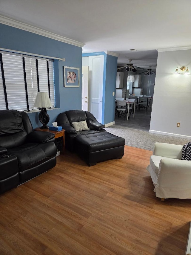 living area featuring ornamental molding, wood finished floors, a ceiling fan, and baseboards