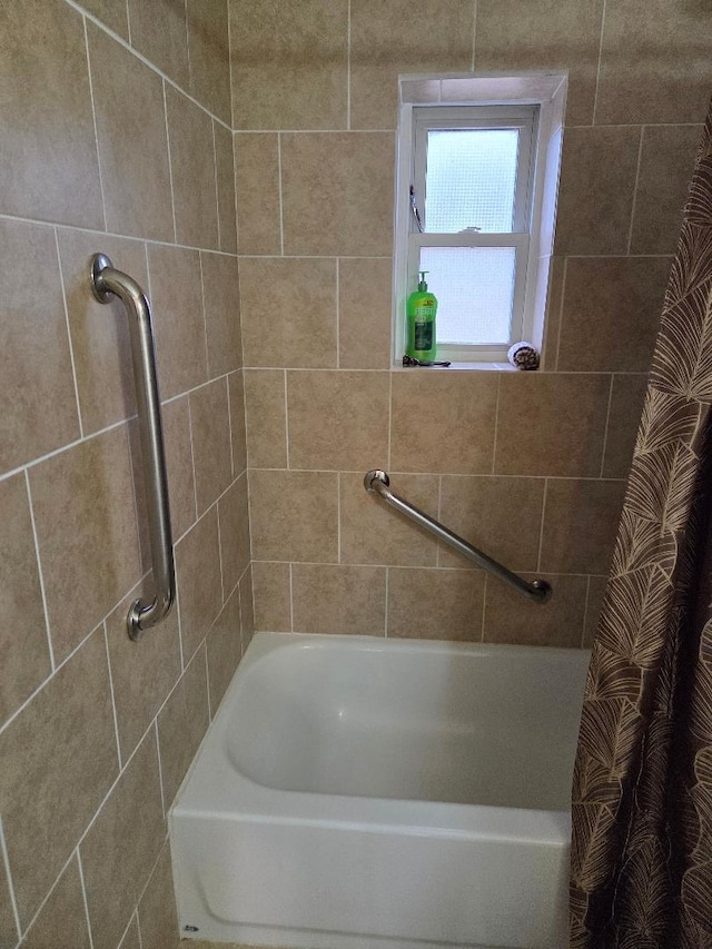 bathroom featuring curtained shower and a washtub